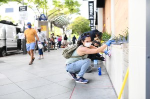 People help clean graffiti off a building facade in Santa Monica.