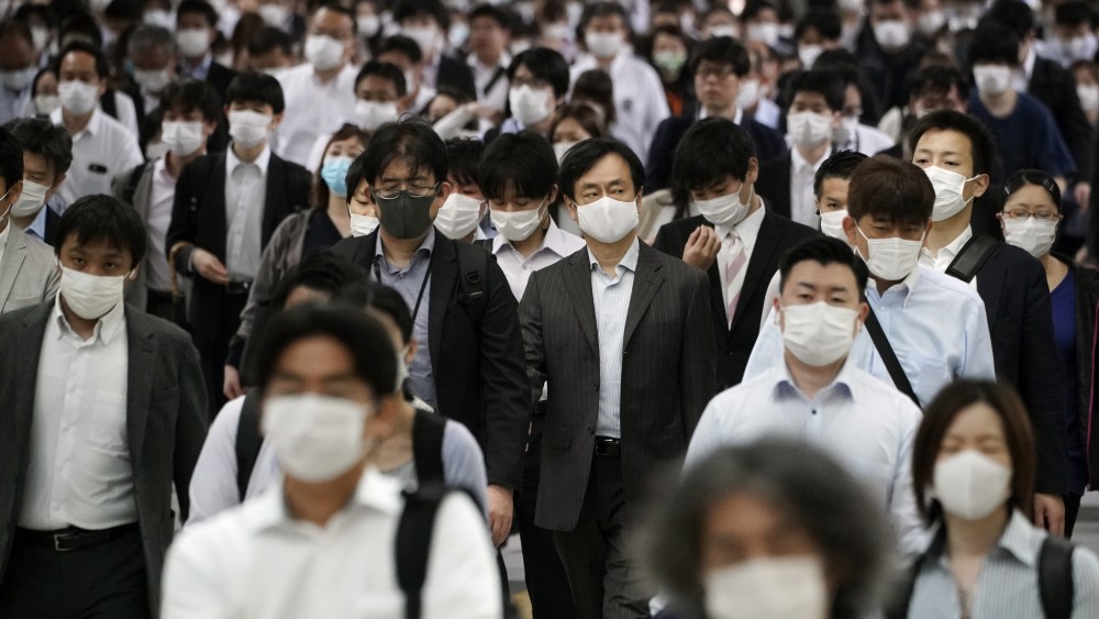 A Tokyo station is crowded with commuters wearing face mask during rush hour, May 2020.