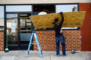 A man boards up a window in Philadelphia.