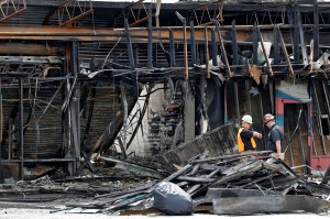 Two workers inspect the damage to a sporting goods store, in Tampa, Florida.