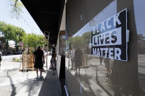 Workers board up businesses damaged during overnight protests in Walnut Creek, California.