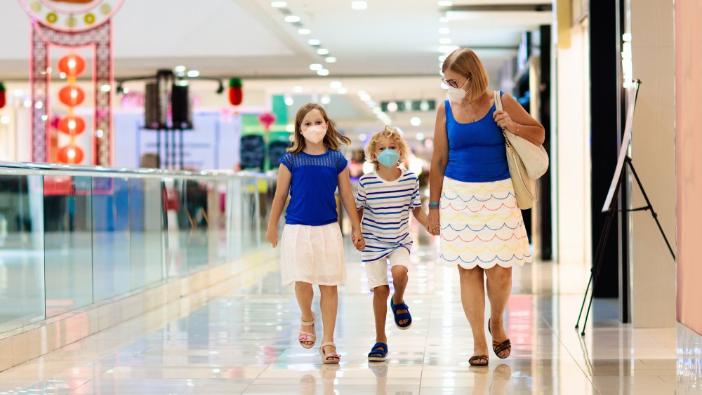Family wearing face mask in shopping mall in Asia. Mother and children wear facemask during coronavirus and flu outbreak in China. Virus and illness protection. Kids in masks in public crowded place.