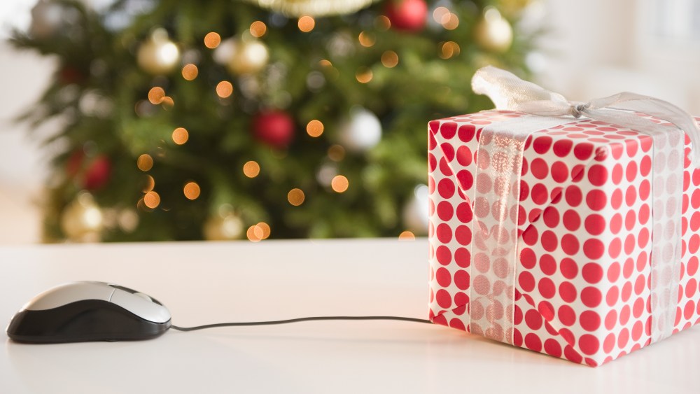 Computer mouse connected to Christmas gift (Photo by: Tetra Images/AP Images)