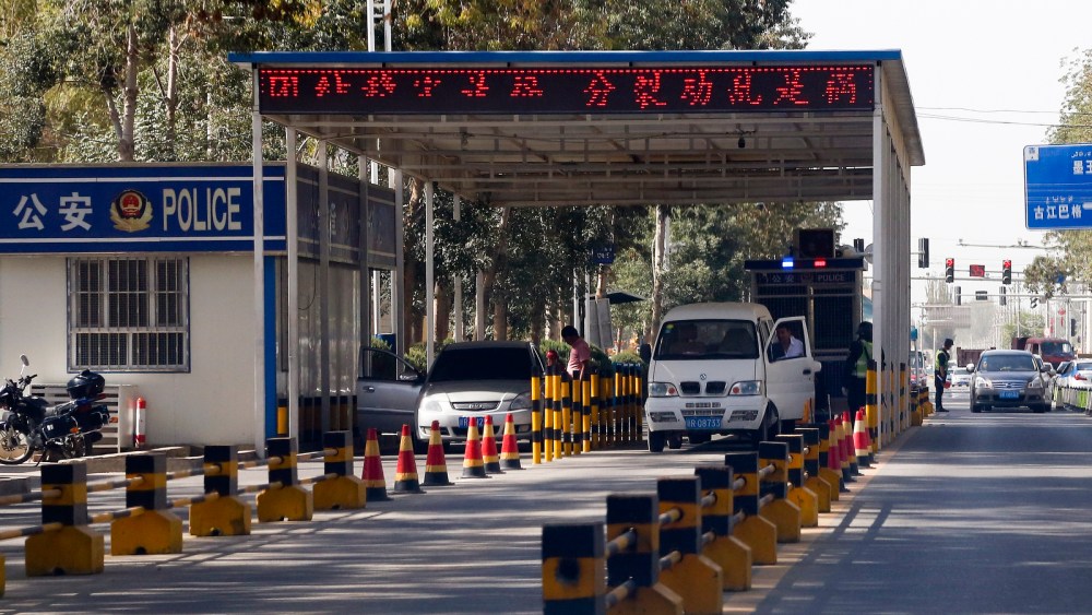 In this Sept. 21, 2018, photo, Uighur drivers have their vehicles checked at a police check point in Hotan, in western China's Xinjiang region.