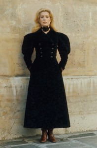 Catherine Deneuve posing for Paris Match magazine in 1970 near the Saint Laurent Rive Gauche store in Paris wearing the designer's black velvet coat.