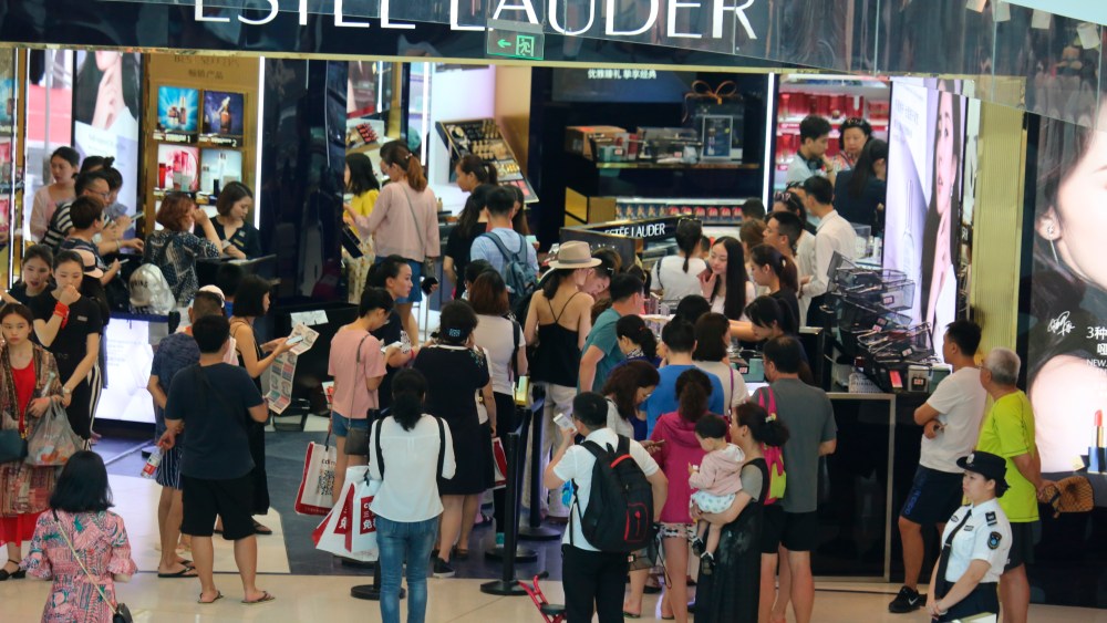Customers shop at a cosmetics store of Estee Lauder in a duty-free shop at Haitang Bay, in Sanya city, south China's Hainan province.