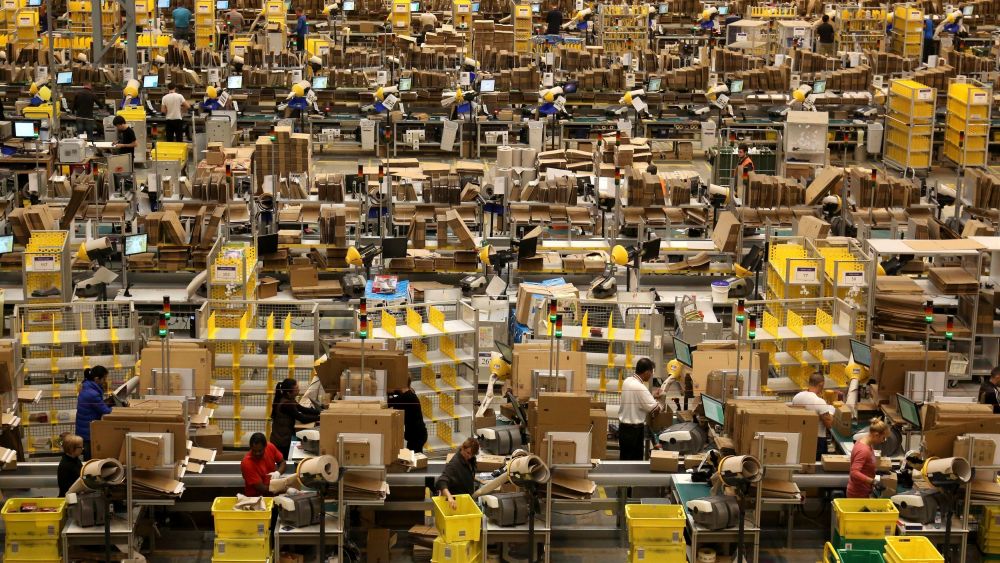 Amazon workers packing orders on the warehouse floor at the Amazon UK Fulfilment Centre in Peterborough, Cambridgeshire.