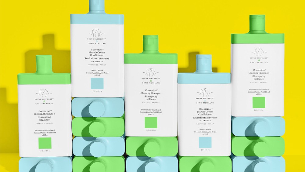 stacked bottles of Drunk Elephant Cocomino Glossing Shampoo