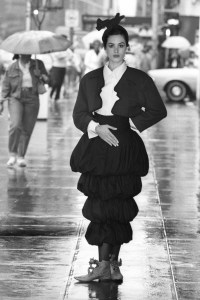 Model wearing Sybilla's Madrid "kiss" jacket in loden green and black wool flannel, ivory linen and rayon blouse, and black wool flannel tiered bubble skirt on September 8, 1987 in New York.
