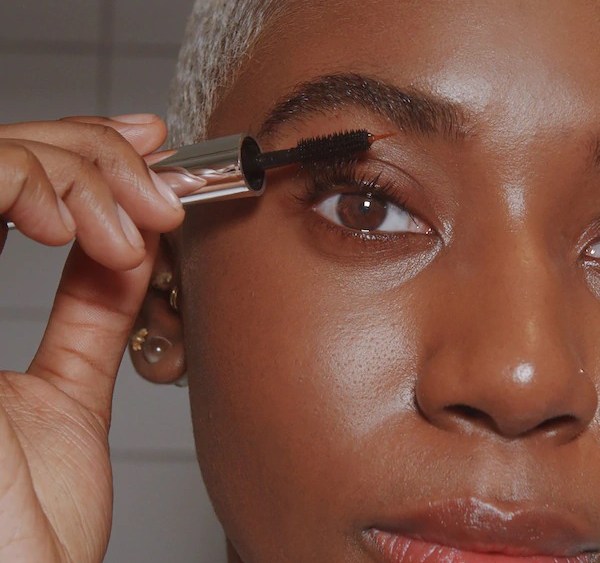 A woman applying the Peter Thomas Roth Lashes To Die For Turbo Nighttime Eyelash Treatment
