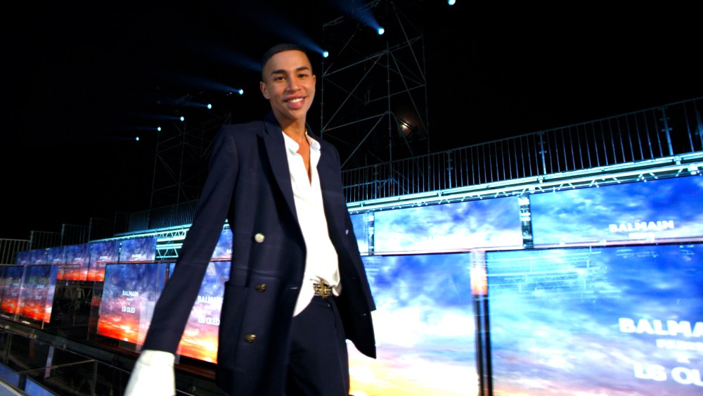 Balmain's Olivier Rousteing at Paris Fashion Week, set against a virtual front row equipped with LG displays.