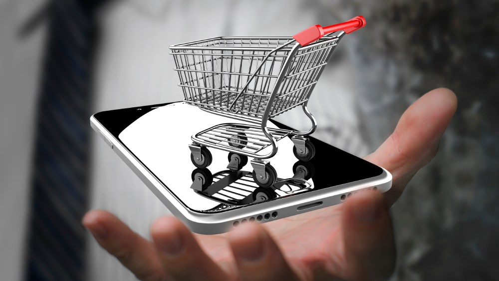 Businessman hand showing shopping cart with smart phone, on line shopping concept. (GDA via AP Images)