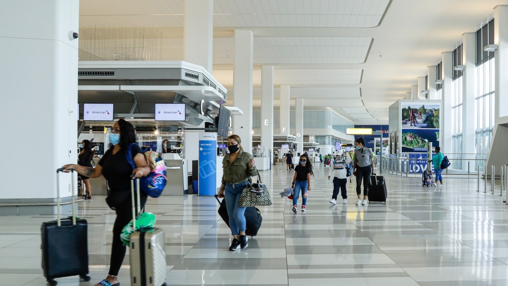People arrive at the ticketing area inside Terminal B at LaGuardia Airport Wednesday, July 15, 2020, in New York. (AP Photo/Frank Franklin II)
