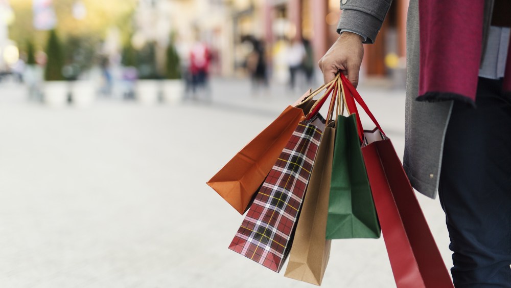 Man holding shopping bags with presents on the street