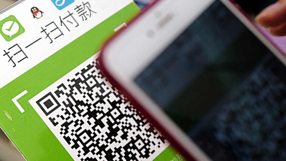 A Chinese mobile phone user scans a QR code via mobile payment service WeChat Pay of Tencent to pay his purchase.