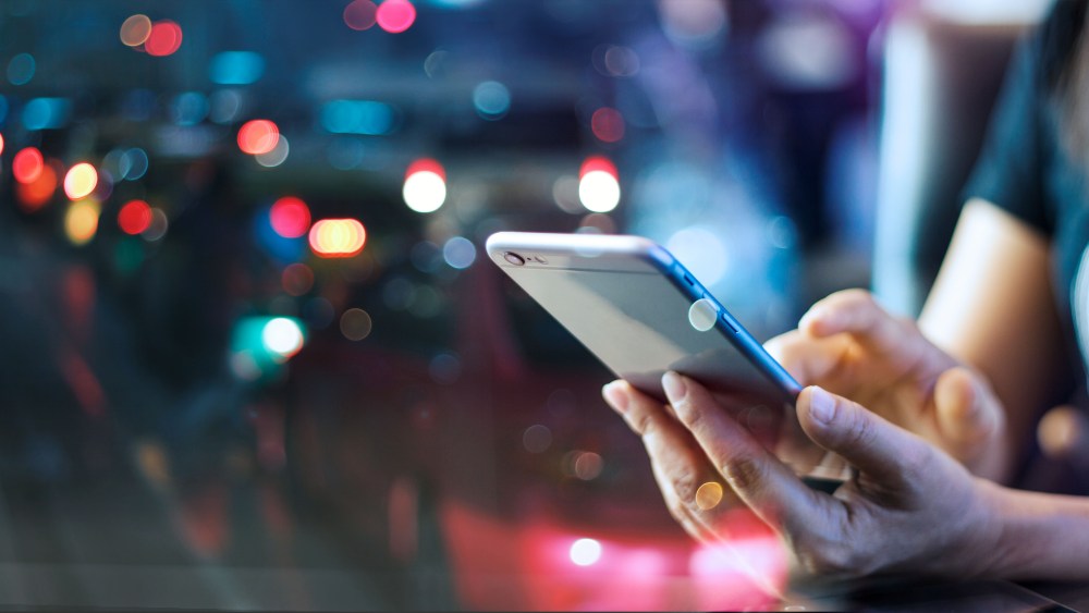 Woman using mobile smart phone in the night light colorful background