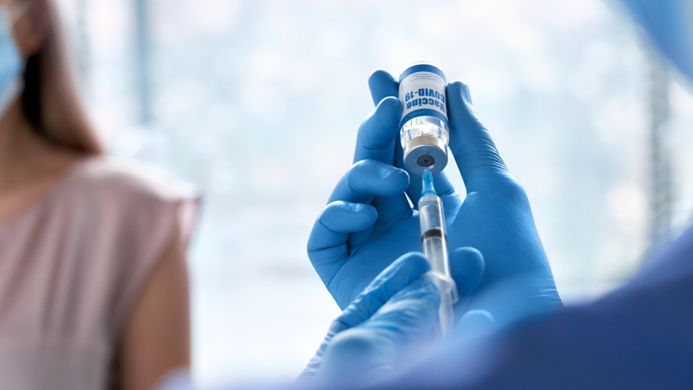 doctor wearing gloves holding syringe taking coronavirus vaccine dose from vail preparing for covid 19 vaccination for patient. Flu influenza vaccine clinical corona virus treatment close up view