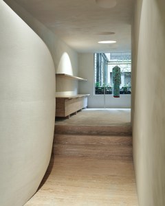 A pillow-like gypsum structure narrows a corridor towards the rear of the main floor.