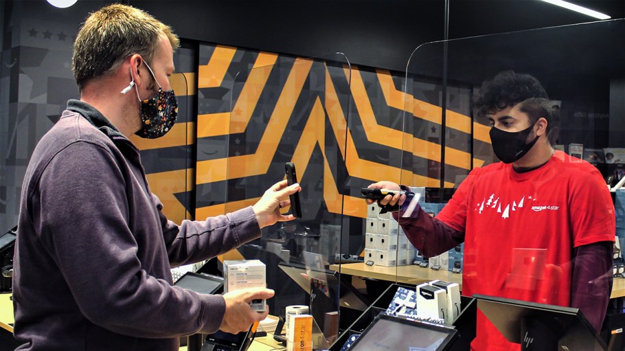 An Amazon customer is getting a QR code scanned on his mobile phone to complete an in-person return.