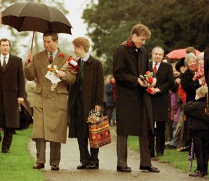 Britain's Prince Charles, left, with his sons Princes Harry, center, and William hold gifts from wellwishers, as they leave the Church on the Sandringham Estate after the traditional Christmas Day Service attended by the Queen and other members of her immediate family Friday, December 25, 1998. (AP Photo/Fiona Hanson/POOL)