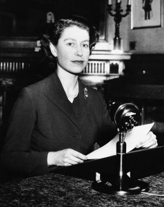 Queen Elizabeth II sits at microphone at Sandringham House as she delivers her first Christmas message to her people in the far-flung British Empire on Dec. 26, 1952. The Queen is spending the holidays at Sandringham. In her message she asked her people ?to keep alive that courageous spirit of adventure.? The Royal Christmas broadcast followed a tradition set by the Queen?s grandfather, George V, and continued by her father the late George VI. (AP Photo)