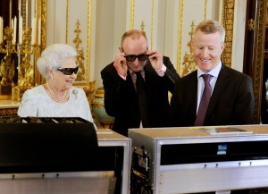 In this image taken Friday Dec. 7, 2012  Britain's Queen Elizabeth II wears 3D glasses  with producer John McAndrew, centre. and director John Bennett in the White Drawing Room of Buckingham Palace in central London,  as they watch the recording of her Christmas message to the Commonwealth which is to be broadcast in 3D for the first time . (AP Photo/ John Stillwell/Pool)