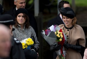 Britain's Queen Elizabeth II's granddaughters Princesses Beatrice, right, and Eugenie, left, hold flowers the Queen received from children after attending the British royal family's traditional Christmas Day church service in Sandringham, England, Tuesday, Dec. 25, 2012.  (AP Photo/Matt Dunham)