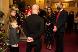 Royal visit to The Palladium. The Duke and Duchess of Cambridge talks to Dom Warren and family, Dom is the founder of Doms Food Mission, as they attend a special pantomime performance at London's Palladium Theatre, hosted by The National Lottery, to thank key workers and their families for their efforts throughout the pandemic. Picture date: Friday December 11, 2020. See PA story ROYAL Cambridge. Photo credit should read: Aaron Chown/PA Wire URN:57055517 (Press Association via AP Images)