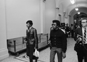 Two members of the Black Panther Party walk to the Assembly Chamber in Sacramento, California, May 2, 1967.