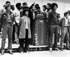 Huey P. Newton, national defense minister of the Black Panther Party, raises his clenched fist behind the podium as he speaks at a convention sponsored by the Black Panthers at Temple University's McGonigle Hall in Philadelphia, Pa., Saturday, Sept. 5, 1970.