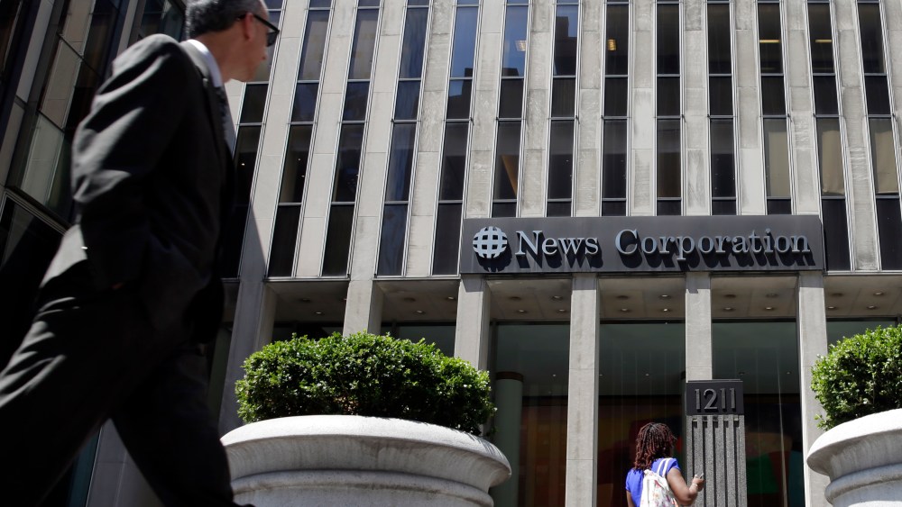 People pass the front of the News Corporation headquarters building in New York, Tuesday, Aug. 1, 2017. (AP Photo/Richard Drew)
