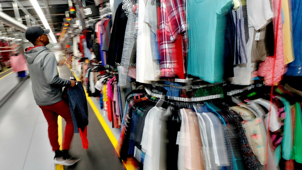 FILE - In this March 12, 2019, file photo Willie Walton hangs clothing on a three-tiered conveyor system at the ThredUp sorting facility in Phoenix. A slew of websites and apps act as virtual thrift stores for vintage devotees, deal hunters and those just looking to unload stuff they don’t want anymore. (AP Photo/Matt York, File)