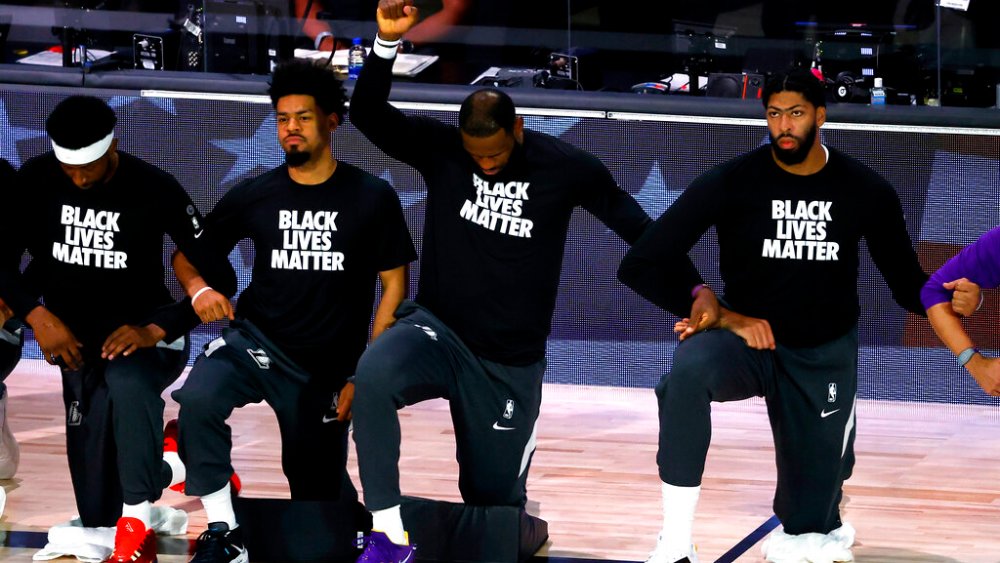 Los Angeles Lakers' LeBron James  kneels during the national anthem prior to the NBA basketball game against the Oklahoma City Thunder Wednesday, Aug. 5, 2020, in Lake Buena Vista, Fla. (Kevin C. Cox/Pool Photo via AP)