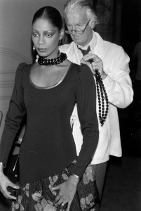 Designer Hubert de Givenchy adjusts a fall 1980 ready to wear look on model Lynn Watts.