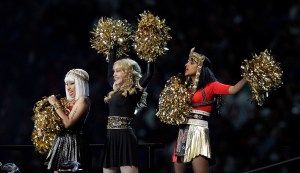 FILE - In this Feb. 5, 2012 file photo, Madonna, center, performs with Nicki Minaj, left, and M.I.A. during halftime of the NFL Super Bowl XLVI football game between the New England Patriots and the New York Giants in Indianapolis. Madonna says she's not happy that M.I.A. made an obscene gesture during the Super Bowl halftime show. Madonna said on Ryan Seacrest's radio show Friday, Feb. 10, that the gesture was pointless and seemed out of place. The British hip-hop artist, invited by Madonna to participate in Sunday's halftime show in front of 114 million people, extended her middle finger to the camera. (AP Photo/Michael Conroy, file)