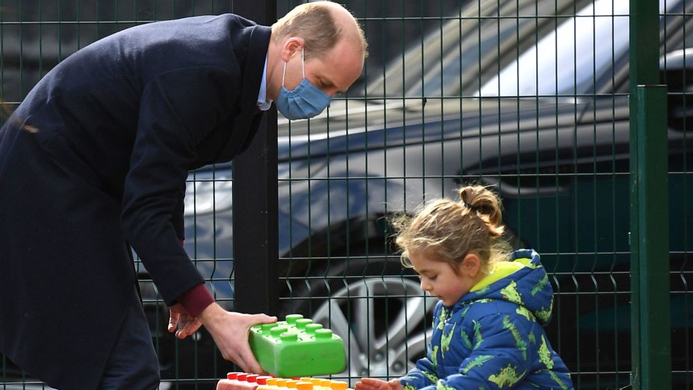 Britain's Prince William plays with a child in the playground during a visit with Kate, Duchess of Cambridge to School21, a school in east London, Thursday March 11, 2021. (Justin Tallis/Pool via AP)