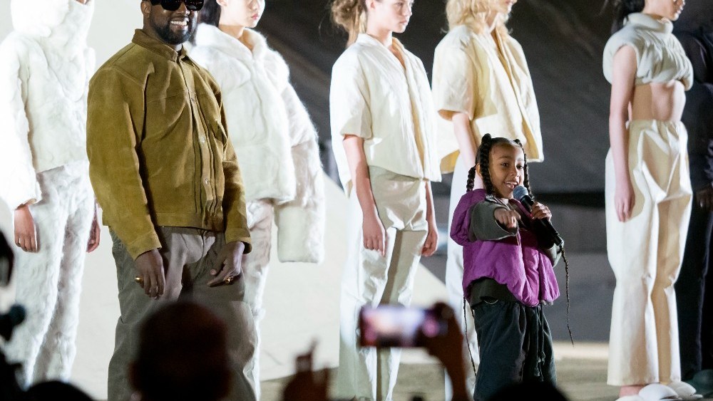 Kanye West stands on stage during the "Yeezy Season 8" show at Paris Fashion Week in March 2020