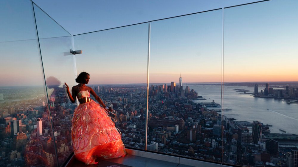 Aeon Elliott models a gown for a fashion shoot while standing on the Edge, an outdoor observation deck overlooking Manhattan, March 2, 2021 in New York. After the virus descended on New York, the only sounds in the streets were wailing ambulance sirens. A year after the pandemic began, the nation's largest metropolis -- with a lifeblood based on round-the-clock hustle and bustle, push and pull -- is adapting and showing new life. (AP Photo/Mark Lennihan)