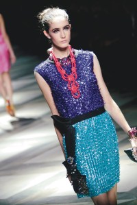 Model on the runway at the Lanvin Spring 2009 show, wearing a sequined blue and purple dress with a large red necklace