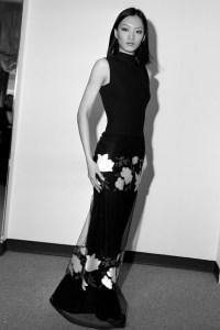 A model poses in a black sleeveless gown with a sheer embroidered overlay from Vera Wang's  Spring 1995 ready to wear collection advance.
