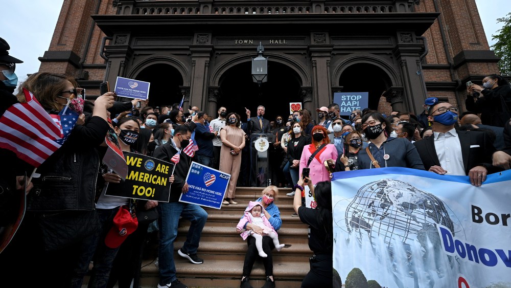 A woman holding her granddaughter sits on the Flushing Town Hall steps as New York City Mayor Bill de Blasio speaks at the "We Belong Here: Queens Rises Against Hate" rally in the Queens borough of New York City, NY, May 2, 2021. Residents representing the diverse asian population of Queens (and other boroughs) were joined by community leaders and politicians, including U.S. Rep. Grace Meng and New York State Attorney General Letitia James, at the anti-hate rally in a show of solidarity for Asian-American community across the United States who have been victims of targeted hate crimes. (Photo by Anthony Behar/Sipa USA)(Sipa via AP Images)