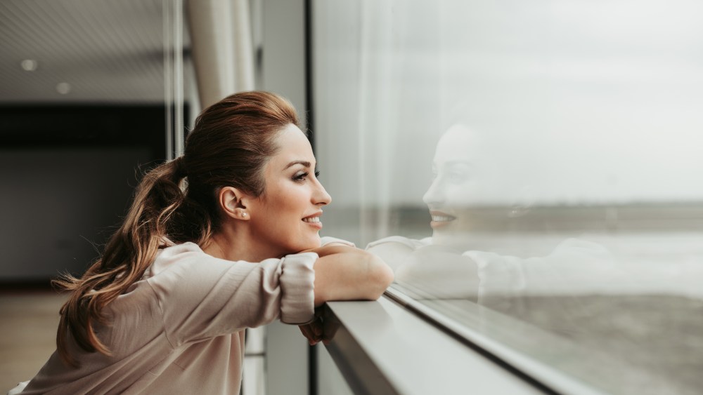 Side view happy woman dreaming while looking at window indoor. She having rest during labor