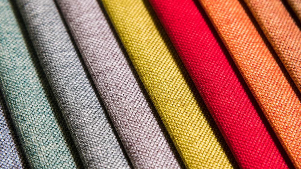 Colorful and bright fabric samples of furniture and clothing upholstery. Close-up of a palette of textile abstract diagonal stripes of different colors.