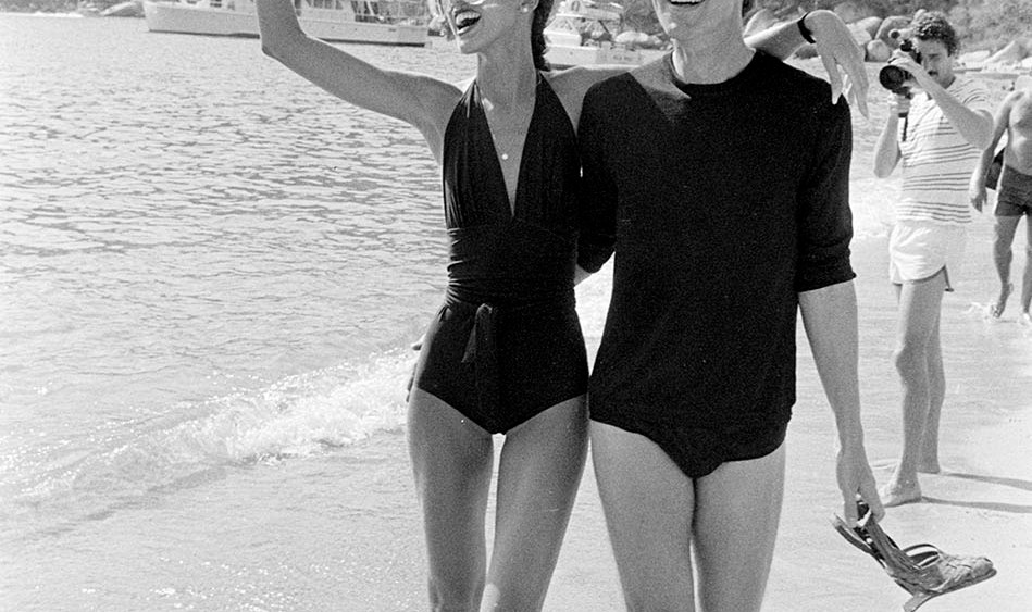 Designer Roy Halston and model Pat Cleveland on the beach during Braniff's "Three Evenings to Remember in Acapulco" event on March 16,1977.