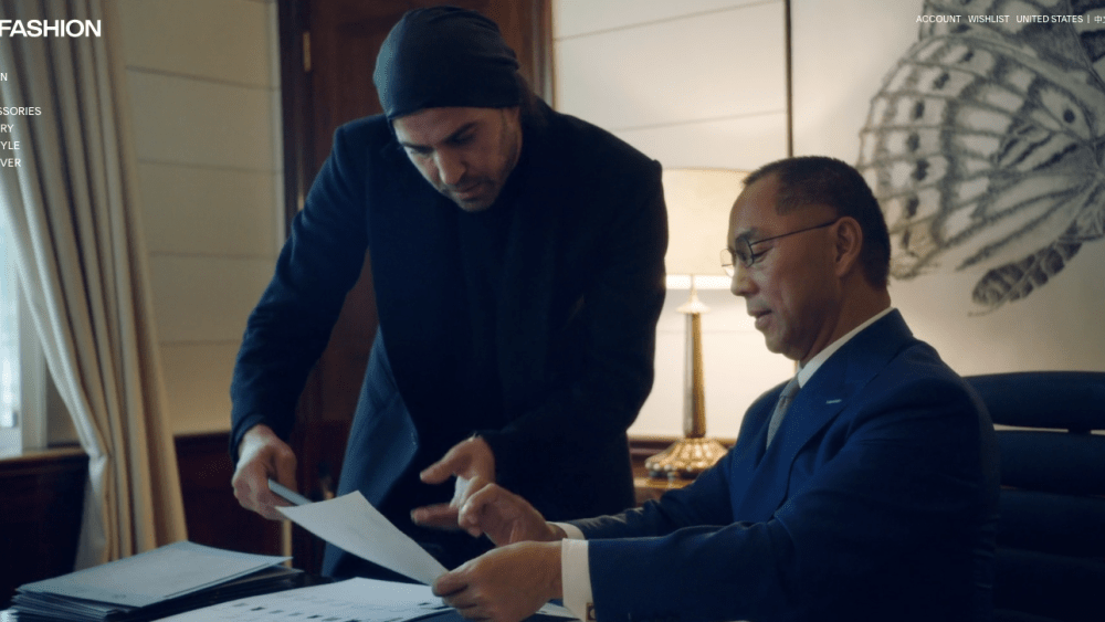 Guo Wengui, seated, looks over design sketches in an image from the G Fashion homepage.