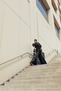 Rick Owens’ nylon coat, stretch denim dress, jersey t-shirt and cotton mask. Moncler glasses; Chanel bracelet.