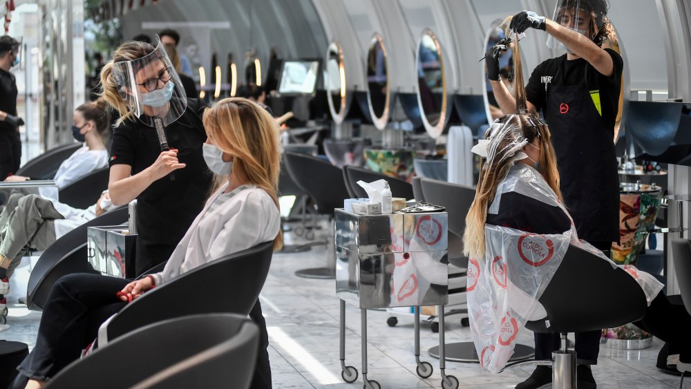 Clients get their hair done at a hairdresser in Milan, Italy, Monday, May 18, 2020 as Italy is slowly lifting sanitary restrictions after a two-month coronavirus lockdown. (Claudio Furlan/LaPresse via AP)