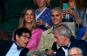 Wimbledon 2021 - Day One - The All England Lawn Tennis and Croquet Club. Romeo Beckham (centre) with girlfriend Mia Regan (left) in the stands on Centre Court on day one of Wimbledon at The All England Lawn Tennis and Croquet Club, Wimbledon. Picture date: Monday June 28, 2021. See PA story TENNIS Wimbledon. Photo credit should read: John Walton/PA Wire. RESTRICTIONS: Editorial use only. No commercial use without prior written consent of the AELTC. Still image use only - no moving images to emulate broadcast. No superimposing or removal of sponsor/ad logos. URN:60632222 (Press Association via AP Images)