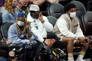 Musician Lil Wayne, left, and Arizona Cardinals quarterback Kyler Murray, right, watch Game 5 of basketball's NBA Finals between the Phoenix Suns and the Milwaukee Bucks, Saturday, July 17, 2021, in Phoenix. (AP Photo/Matt York)