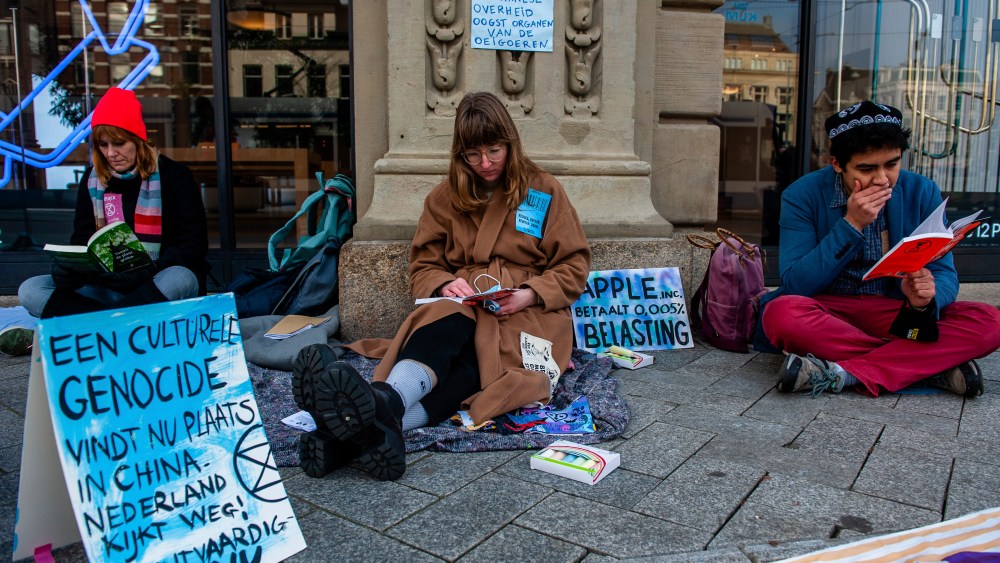 Activists from the climate organization Extinction Rebellion carried out an action against the Apple brand in front of the Apple Store in the center of Amsterdam. According to the activists, Apple is pitching against human rights legislation. The activists performed a song against labor slavery and carried out and a read-in action by reading books, sitting outside of the store, on November 28th, 2020. (Photo by Romy Arroyo Fernandez/NurPhoto via AP)